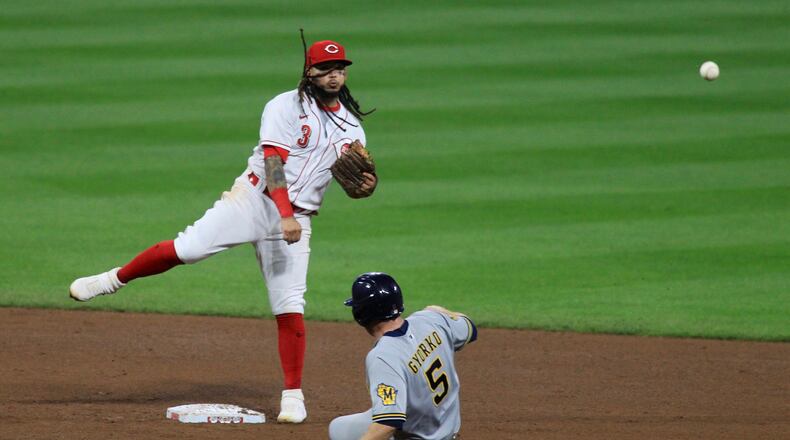 Reds second baseman Freddy Galvis turns a game-ending double play against the Brewers on Wednesday, Sept. 23, 2020, at Great American Ball Park in Cincinnati. David Jablonski/Staff