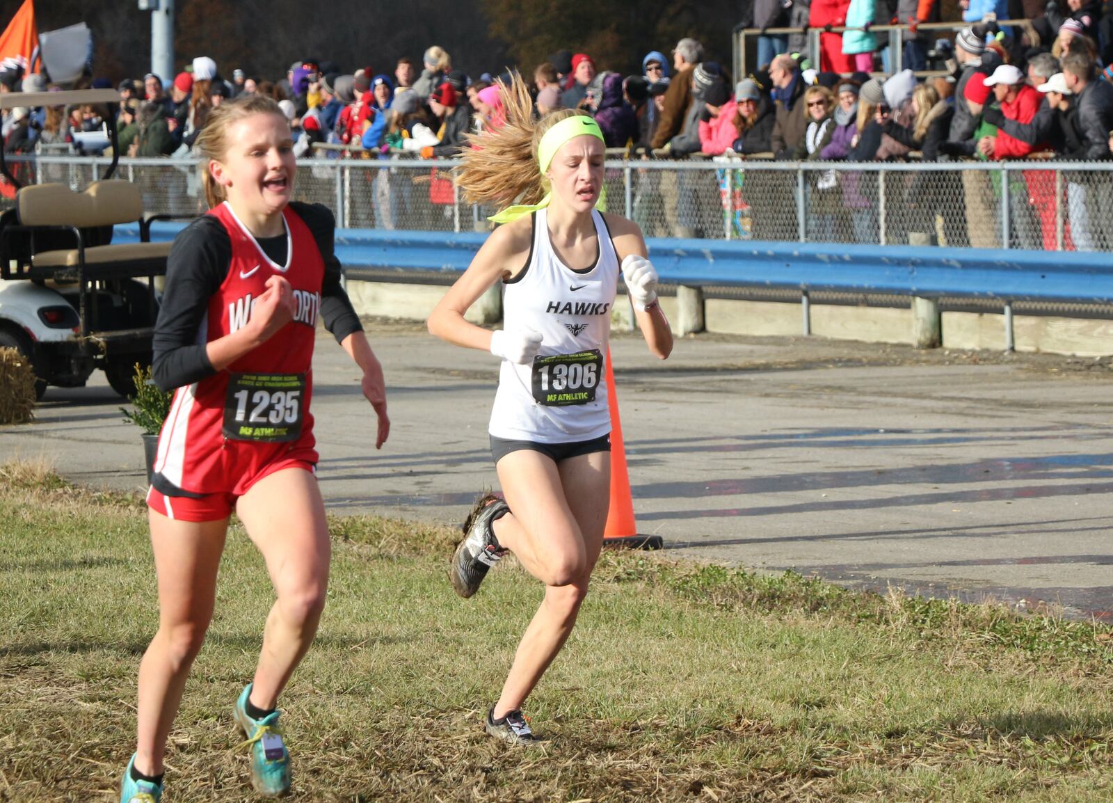 Lakota East’s Kelsi Harris (right) heads toward the finish line Saturday during the Division I state cross country championship race at National Trail Raceway in Hebron. CONTRIBUTED PHOTO BY GREG BILLING