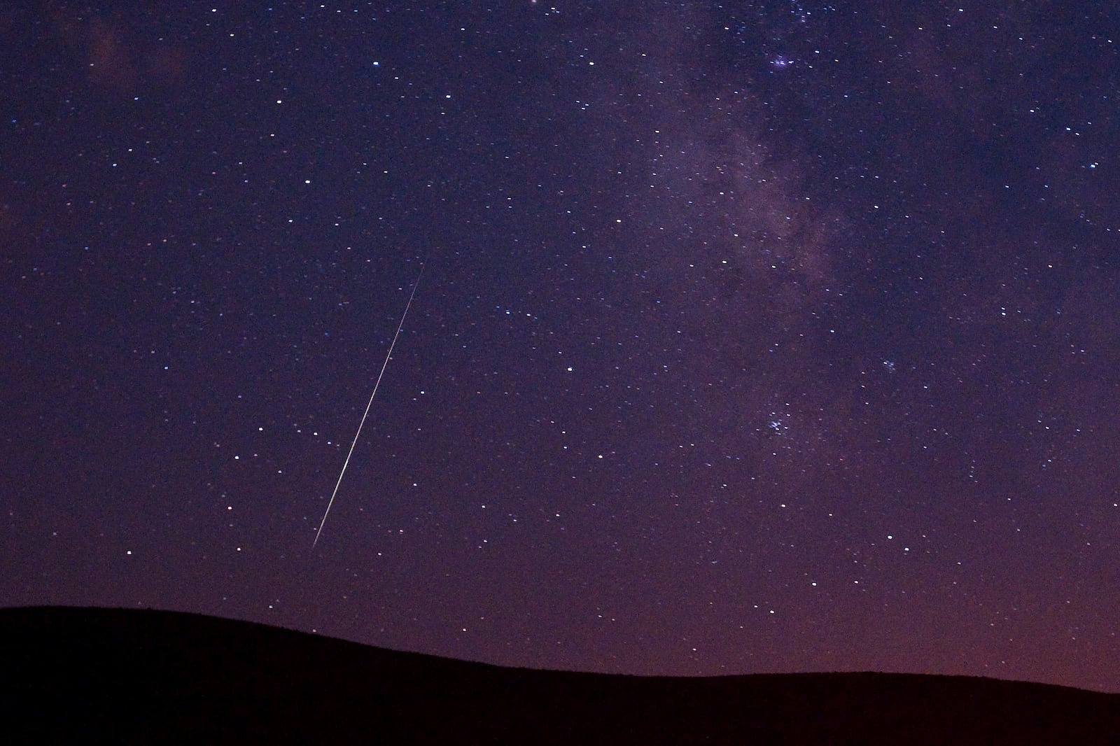 FILE - A Perseid meteor streaks across the sky during the Perseid meteor shower in Vinton, California, Aug. 11, 2009. (AP Photo/Kevin Clifford, File)