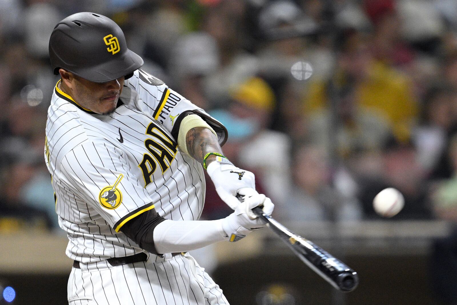 San Diego Padres' Manny Machado hits a home run against the Arizona Diamondbacks during the eighth inning of a baseball game against the Arizona Diamondbacks Monday, July 7, 2025, in San Diego. (AP Photo/Orlando Ramirez)