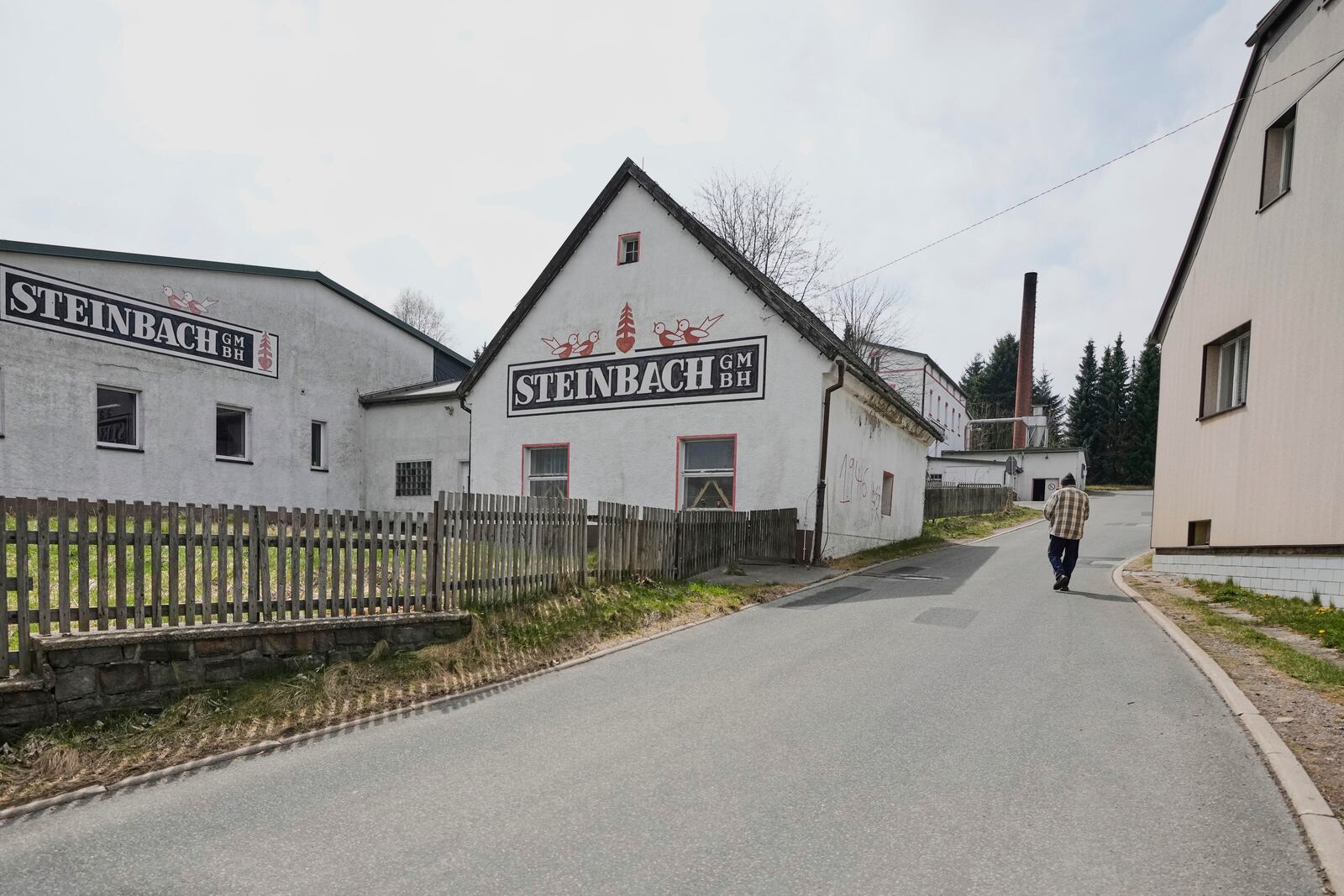 A man walks on the road near the Steinbach-Volkskunst nutcracker factory in Marienberg, Germany, Tuesday, April 15, 2025. (AP Photo/Markus Schreiber)