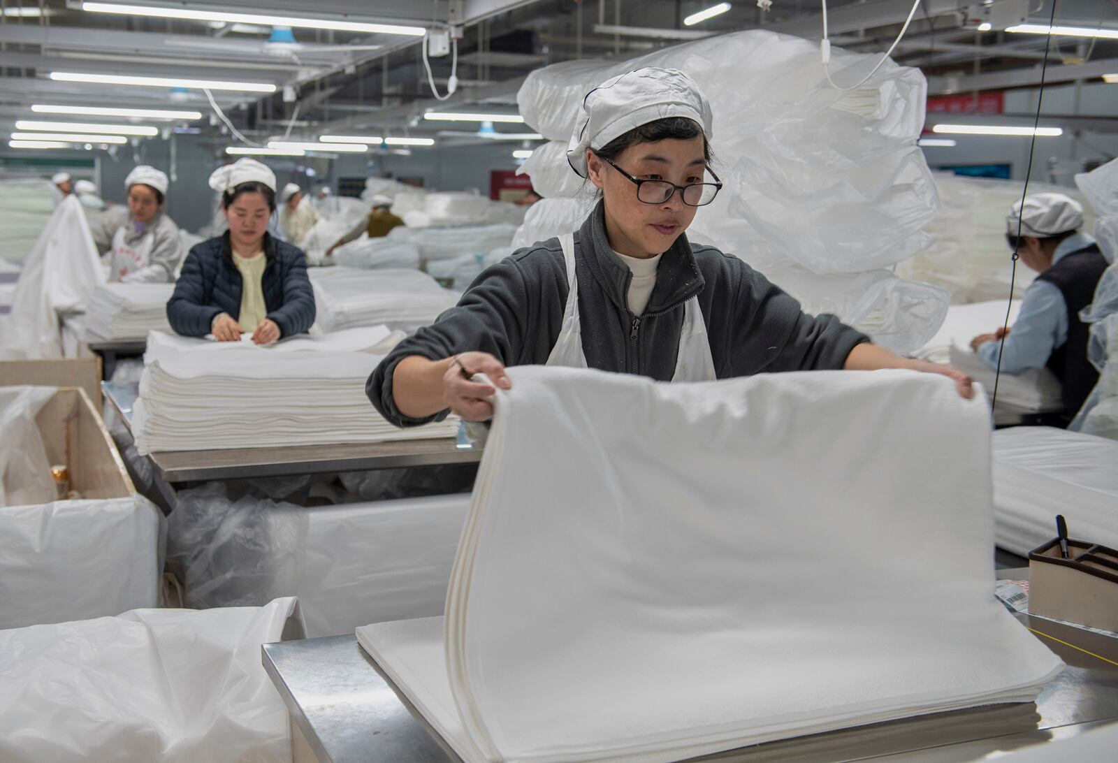 Workers labor on the production line of towels at a textile manufacturer in Huai'an city in east China's Jiangsu province, Wednesday, April 2, 2025. (Chinatopix Via AP)