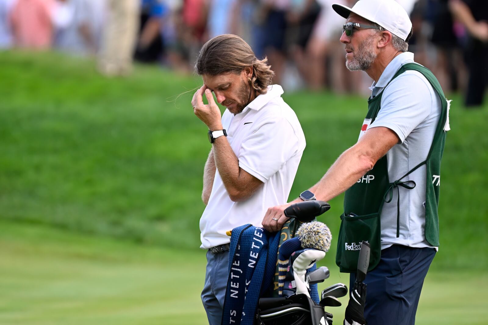 Tommy Fleetwood, from England, reacts as Keegan Bradley prepares to putt for the win during the final round of the Travelers Championship golf tournament at TPC River Highlands, Sunday, June 22, 2025, in Cromwell, Conn. At right is Fleetwood's caddie Ian Finnis. (AP Photo/Jessica Hill)