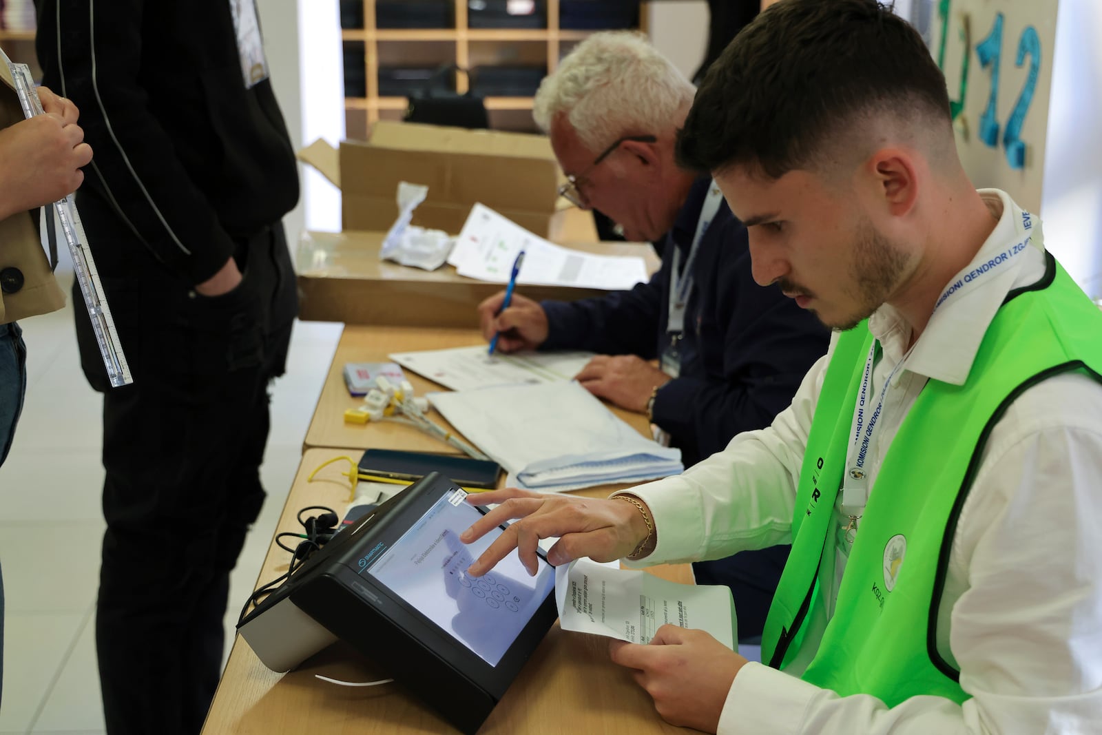 A man checks documents during a general election in Tirana, Albania Sunday, May 11, 2025. (AP Photo/Vlasov Sulaj)