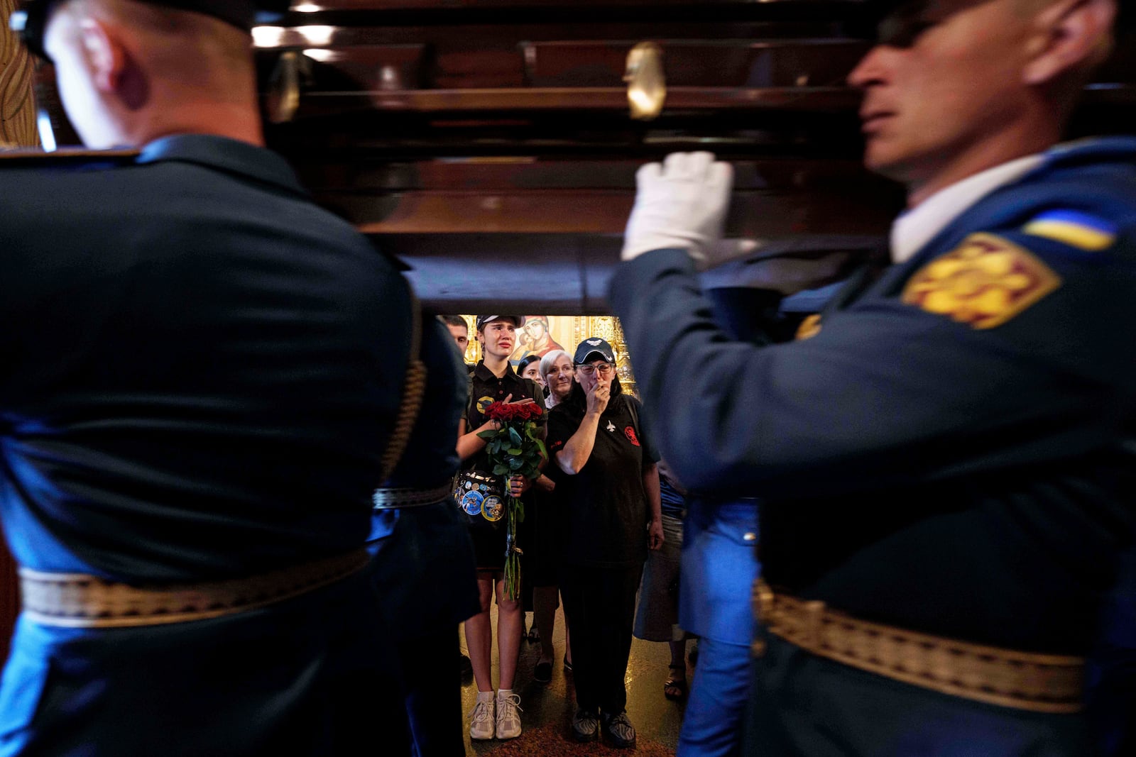Women cry while honor guards carry the coffin of Ukrainian F-16 pilot Maksym Ustymenko, during a farewell ceremony in Kyiv, Ukraine, on Thursday, July 3, 2025. (AP Photo/Evgeniy Maloletka)