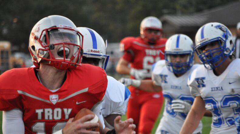 Troy quarterback Sam Coleman reacts after scrambling for an 11-yard touchdown during the Trojans’ 28-6 win against Xenia earlier this season. NICK DUDUKOVICH / CONTRIBUTED