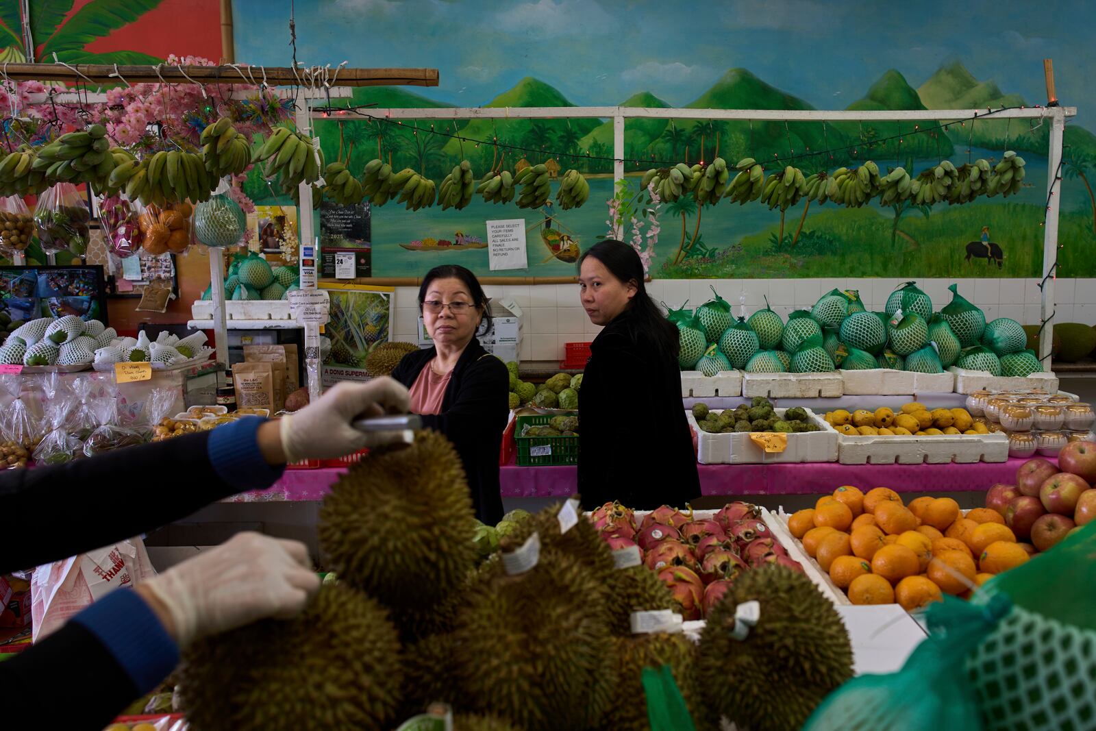 Two Vietnamese women shop for fruit at a market in the Little Saigon neighborhood of Westminster, Calif., Friday, April 25, 2025. (AP Photo/Jae C. Hong)