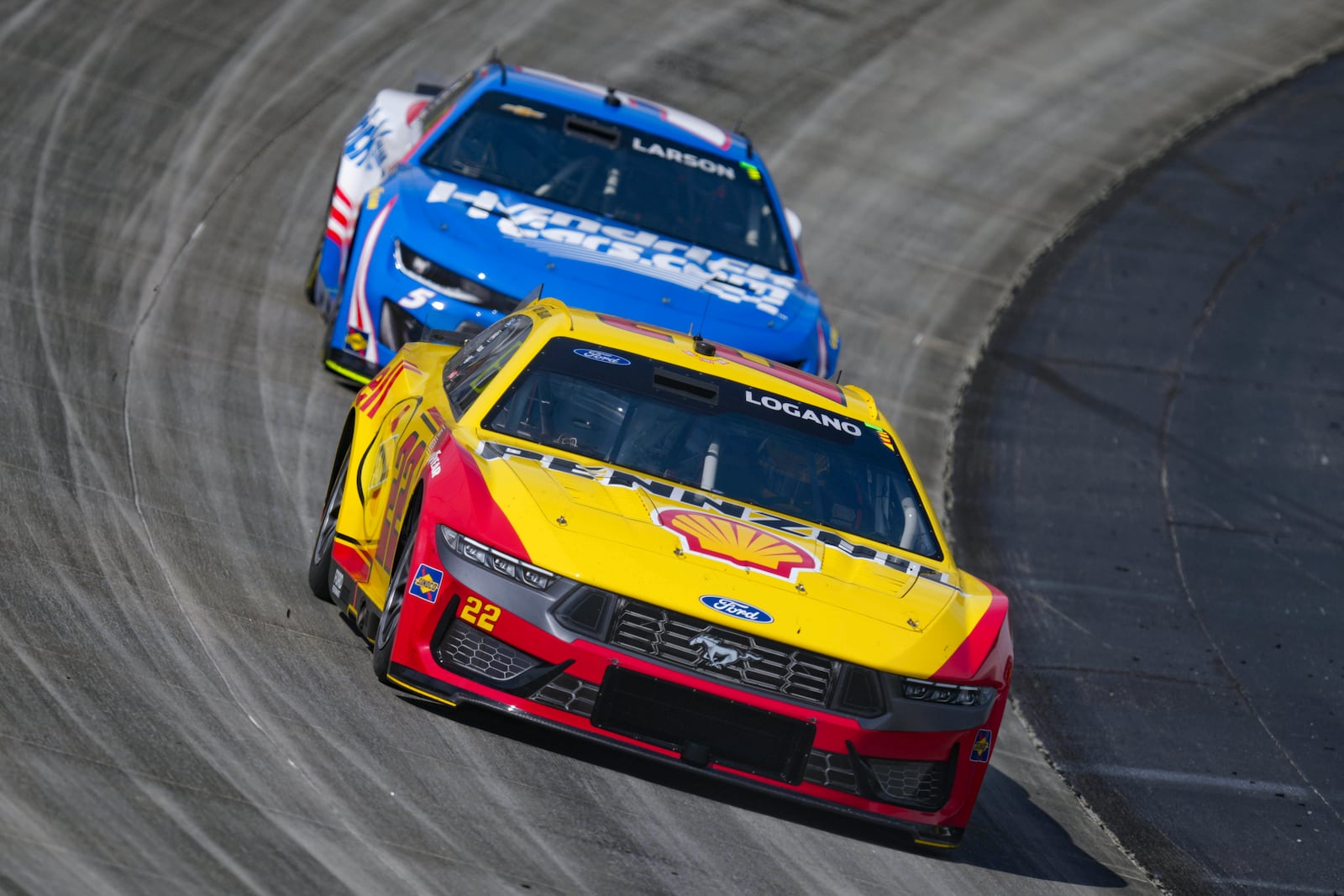 Joey Logano, front, drives ahead of Kyle Larson through Turn 2 during a NASCAR Cup Series auto race at Dover Motor Speedway, Sunday, July 20, 2025, in Dover, Del. (AP Photo/Derik Hamilton)