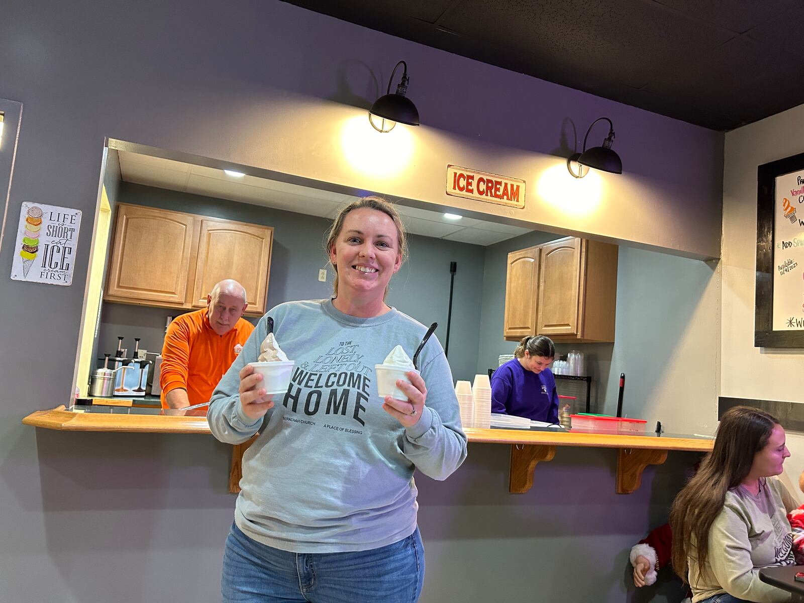 Tiffany Biddle, a volunteer from Berachah Church, delivers ice cream from the Cone to customers Monday night during the second annual Brent's Christmas BBQ Blessing. RICK McCRABB/STAFF