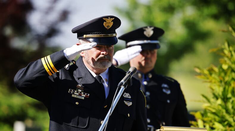 Acting Middletown Police chief Andy Warrick, left, and Det. Connor Kirby salute the flag during a memorial ceremony for fallen officers Thursday, May 16, 2014 at Woodside Cemetery and Arboretum in Middletown. NICK GRAHAM/STAFF