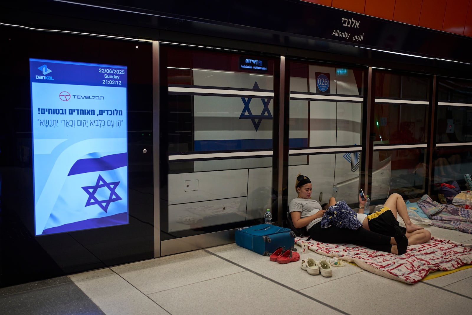People take shelter in an underground metro station as air raid sirens warn of incoming strikes by Iran, in Tel Aviv, Israel, Sunday, June 22, 2025. (AP Photo/Ohad Zwigenberg)