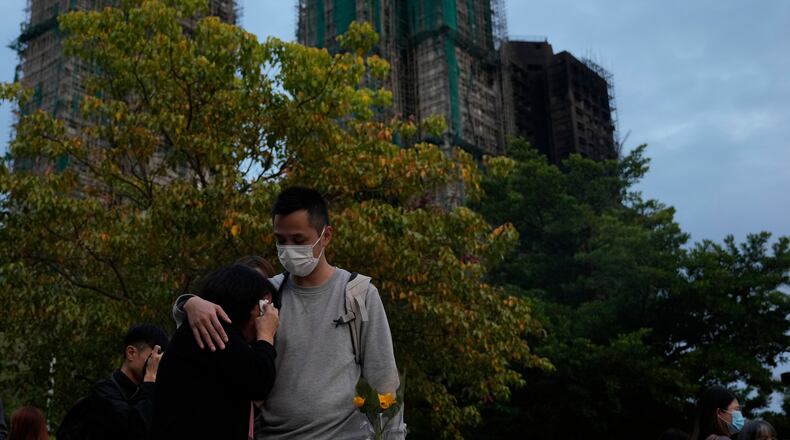 A man consoles a woman at the site of last weeks deadly fire at Wang Fuk Court, a residential estate in the Tai Po district of Hong Kong's New Territories on Tuesday, Dec. 2, 2025. (AP Photo/Ng Han Guan)