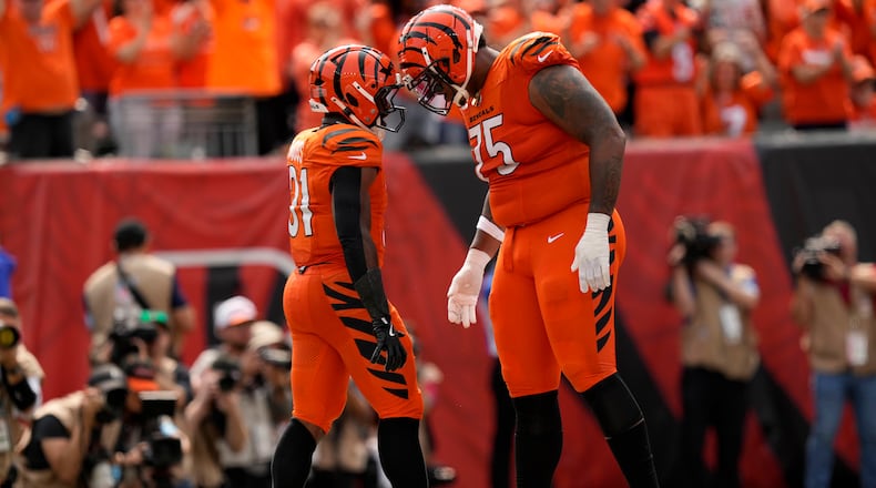 Cincinnati Bengals running back Zack Moss (31) celebrates with teammate Orlando Brown Jr. (75) after scoring on a 5-yard touchdown run during the second half of an NFL football game against the New England Patriots, Sunday, Sept. 8, 2024, in Cincinnati. (AP Photo/Carolyn Kaster)