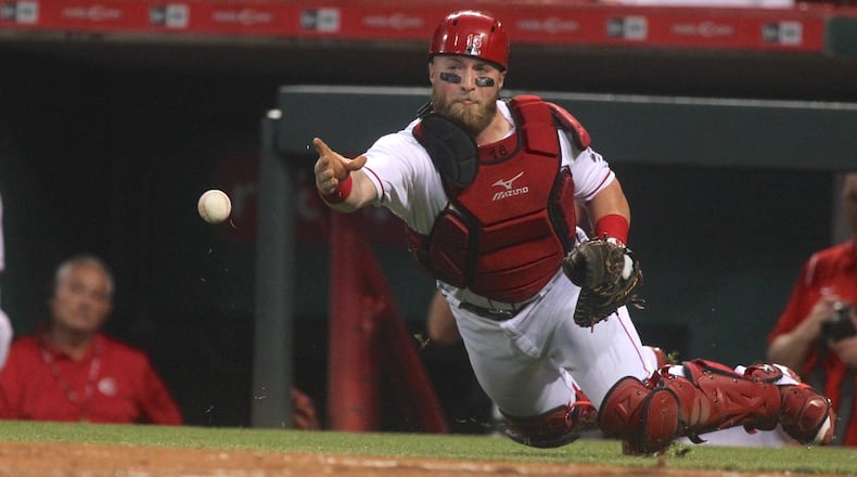 Reds catcher Tucker Barnhart throws to pitcher Homer Bailey at home plate after a wild pitch against the Marlins on Friday, July 21, 2017, at Great American Ball Park in Cincinnati. Giancarlo Stanton scored on the play. David Jablonski/Staff