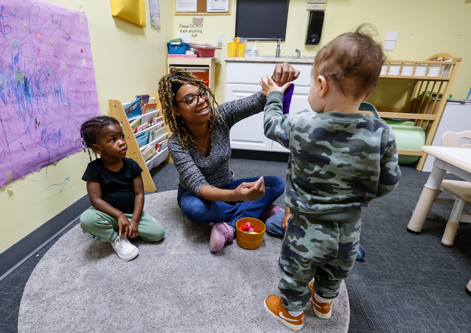 Monica Mills tends to toddlers at Loving Babies N' Tots childcare Thursday, March 19, 2026. Ohio’s recent changes to publicly funded child care reimbursements are putting added pressure on providers already operating on slim margins, including Loving Babies N' Tots owner Markida Jackson of Hamilton. Jackson opened the business four years ago at 3320 Tylersville Road in Fairfield Twp. NICK GRAHAM/STAFF