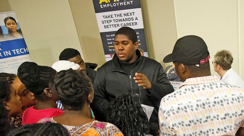 Members of Springfield's Haitian community gather around Bradley Jean, center, as he translates for them at the 14th Annual Clark County Job Fair Wednesday, April 17, 2024. The job fair featured 60 employers looking for skilled and unskilled workers. BILL LACKEY/STAFF
