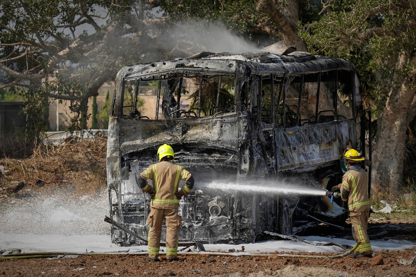 Firefighters work at site hit by a missile launched from Iran in central Israel on Tuesday, June 17, 2025. (AP Photo/Baz Ratner)