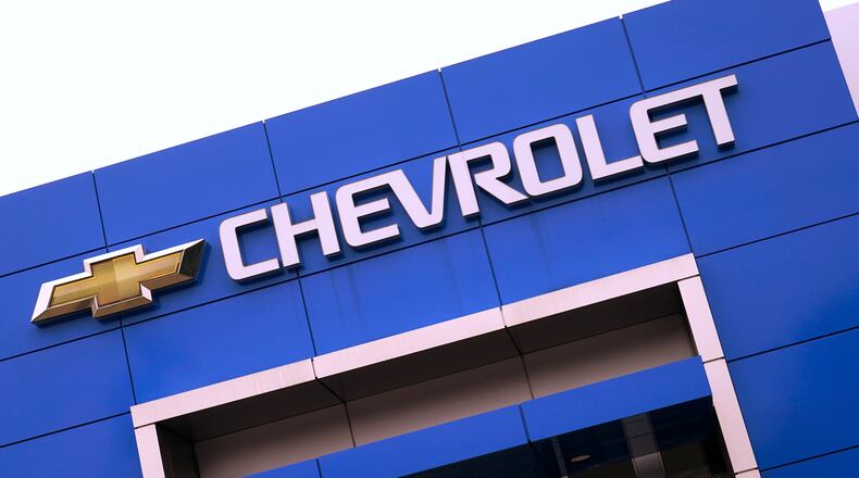 The Chevrolet logo is displayed on the facade of a dealership , Tuesday, Aug. 3, 2021, in Woburn, Mass. Despite a computer chip shortage that temporarily closed some of its factories, General Motors made a healthy $2.8 billion second-quarter net profit in the second quarter. (AP Photo/Charles Krupa)