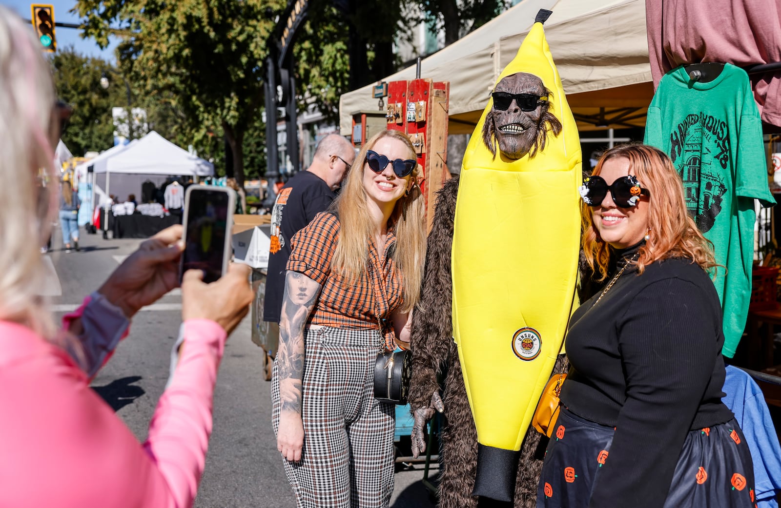 Samantha Barbre, left, and Andrea Ulreich pose for a picture with a bigfoot mannequin at the Unsung Salvage booth as visitors check out vendor booths, food trucks, and pumpkins of all shapes and sizes on High Street during Operation Pumpkin Friday, Oct. 11, 2024 in downtown Hamilton. NICK GRAHAM/STAFF