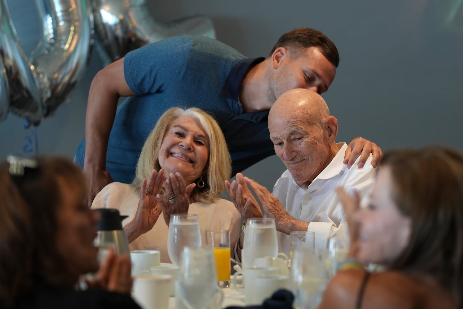 Tyler Terens kisses his grandfather Harold Terens, a World War II veteran who fought in D-Day. after speaking at his 102 birthday party, Saturday, July 26, 2025, in Delray Beach, Fla. (AP Photo/Marta Lavandier)