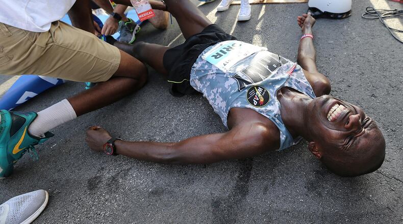 July 04, 2017 Atlanta: Leonard Korir collapses to the street after the finish line winning the 48th running of the AJC Peachtree Road Race with an unofficial time of 28:16 on Tuesday, July 4, 2017, in Atlanta. Curtis Compton/ccompton@ajc.com