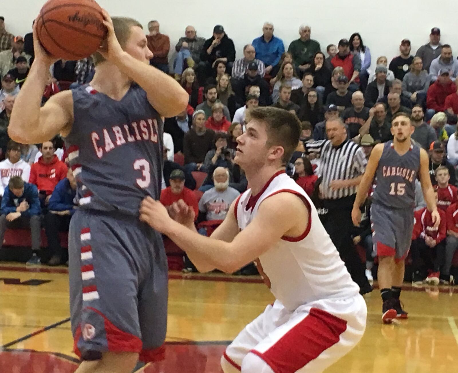 Madison’s Mason Whiteman (right) gets up close and personal with Carlisle’s Jake Moore during a game in Madison Township on Jan. 23. RICK CASSANO/STAFF