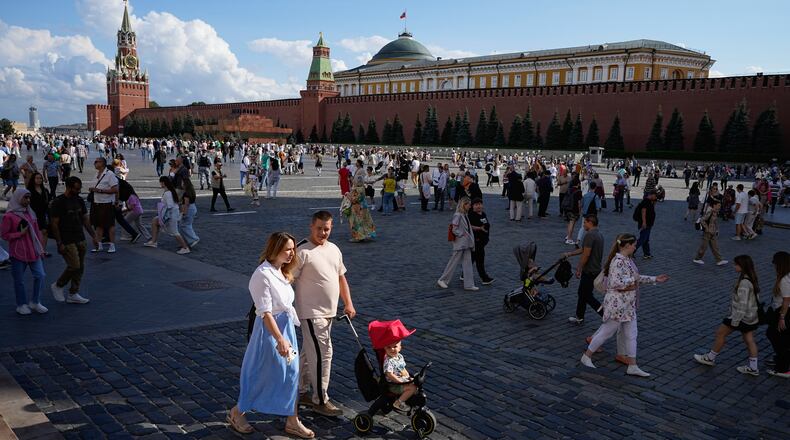 FILE - A family walks through Red Square in Moscow, Russia, Sunday, Aug. 4, 2024. (AP Photo/Alexander Zemlianichenko, File)