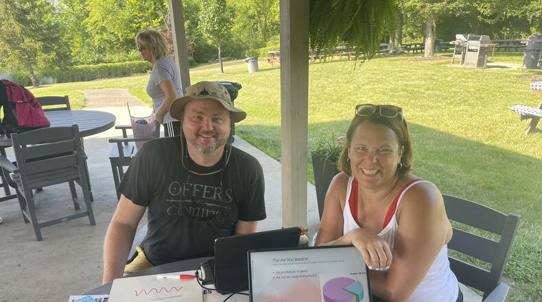 Nick Rakel, left, and Robyn Winegardner, right, own Cincy SCUBA in Hamilton and are seen here June 24, 2025 teaching a mobile course at New London Hills Club, a private tennis and swim club in Hamilton. In front of Rakel is a dive table chart used as part of the coursework. MANDY GAMBRELL/STAFF