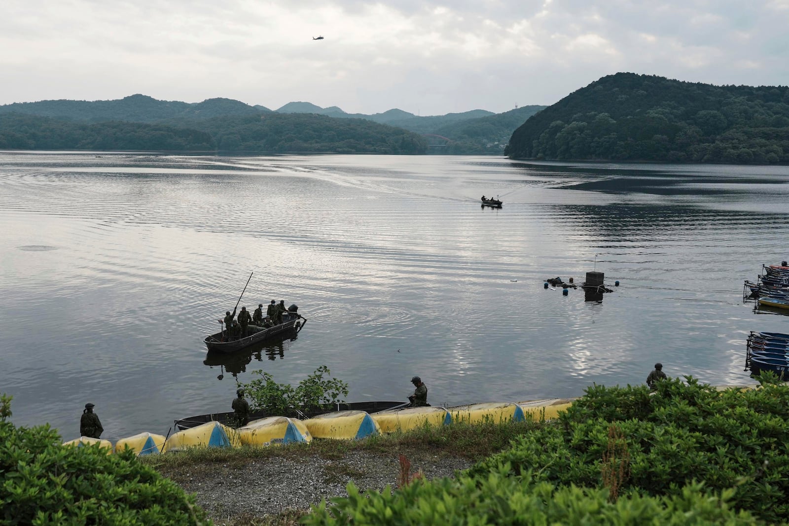 Members of Japan's Self-Defense Forces conduct a search for crew members at a reservoir in Inuyama, central Japan, Thursday, May 15, 2025, following the crash of an Air Self-Defense Force trainer jet Wednesday. (Koji Harada/Kyodo News via AP)