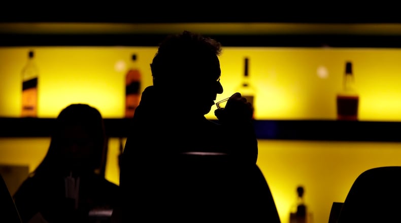 FILE - In this Nov. 30, 2017 photo, a patron sips his drink while having a meal at a bar in New Jersey. More government data points to alcohol's increasing role in U.S deaths, including a new report that found that the alcohol-induced death rate rose nearly 30% during the first year of the COVID-19 pandemic. (AP Photo/Julio Cortez, File)