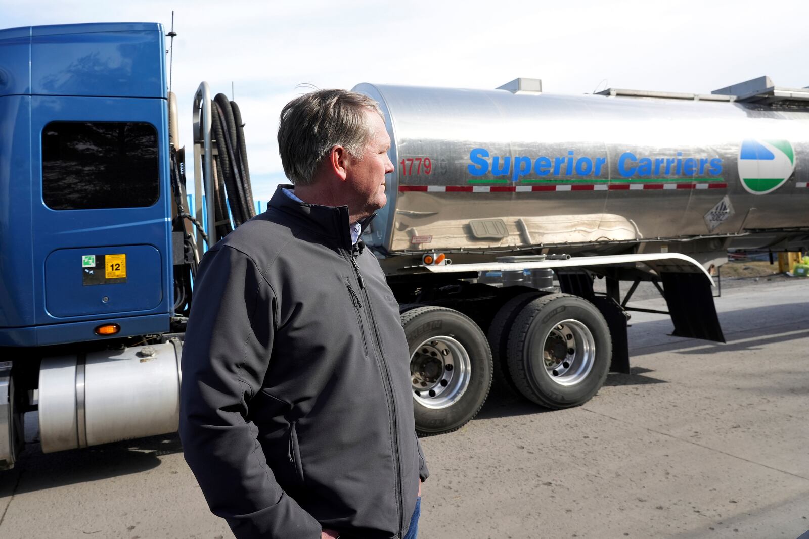 Norfolk Southern President and CEO Alan Shaw pauses as a tanker truck filled with wastewater passes by, Tuesday, Feb. 21, 2023, near the site where a freight train derailed Feb. 3 in East Palestine, Ohio. (AP Photo/Matt Freed)