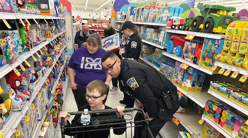 Middletown Division of Police officer Justin Beamis helps Luke Wilburn shop for presents during the Mike Davis Shop with a Cop program on Dec. 13 at the Middletown Meijer. Grandmother Rachel Cobb looks on. RICK MCCRABB/CONTRIBUTED