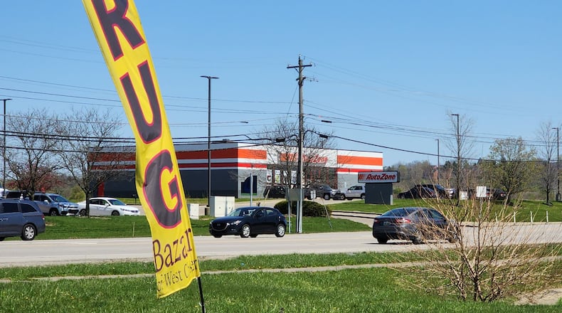 Rug Bazaar in West Chester Township has signs on their building and a temporary blade sign in the grass at the intersection of Union Centre Boulevard and Princeton Glendale Road. NICK GRAHAM/STAFF
