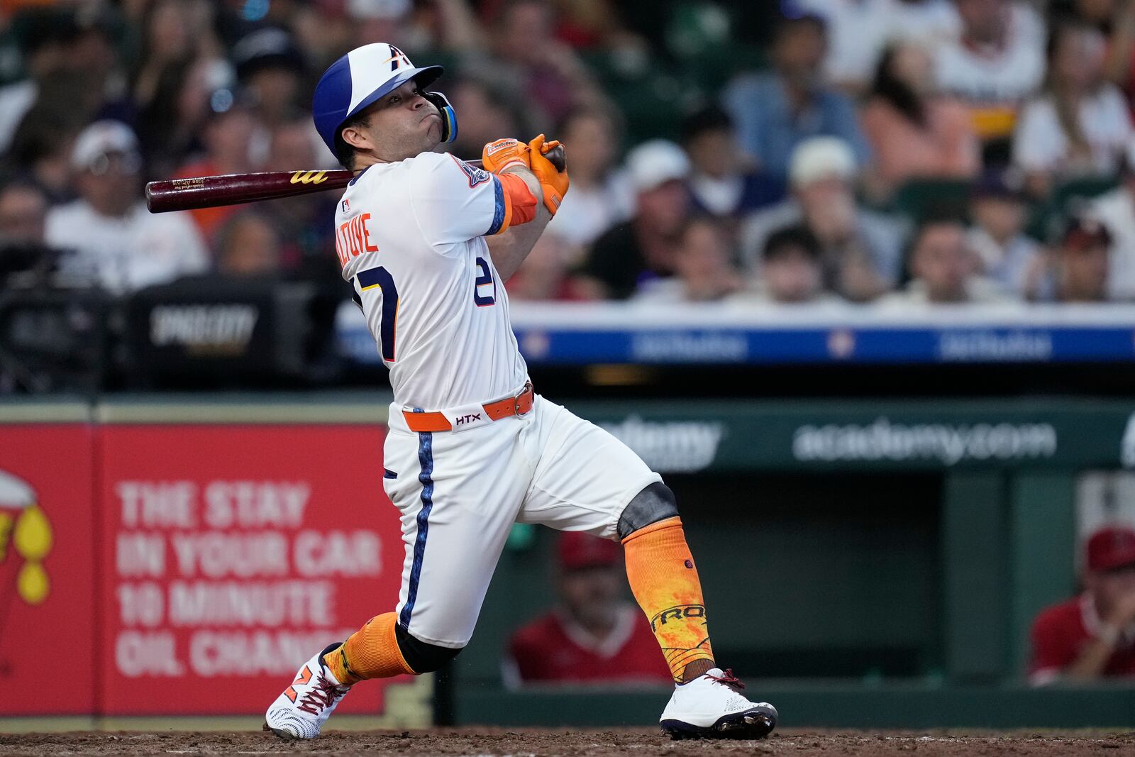 Houston Astros' Jose Altuve hits an RBI sacrifice fly during the seventh inning of a baseball game against the Los Angeles Angels, Sunday, April 13, 2025, in Houston. (AP Photo/Kevin M. Cox)