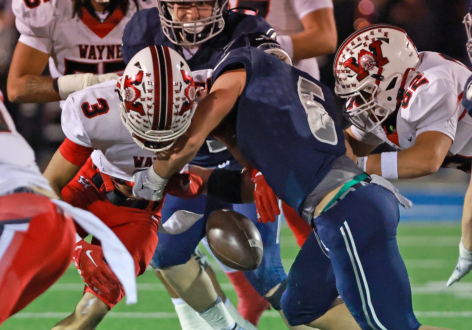 Fairmont's Skyler Slifer forces Wayne's Teaunn Hunter to fumble the ball during round two of the playoffs Friday, Nov. 8, 2024. BILL LACKEY/STAFF