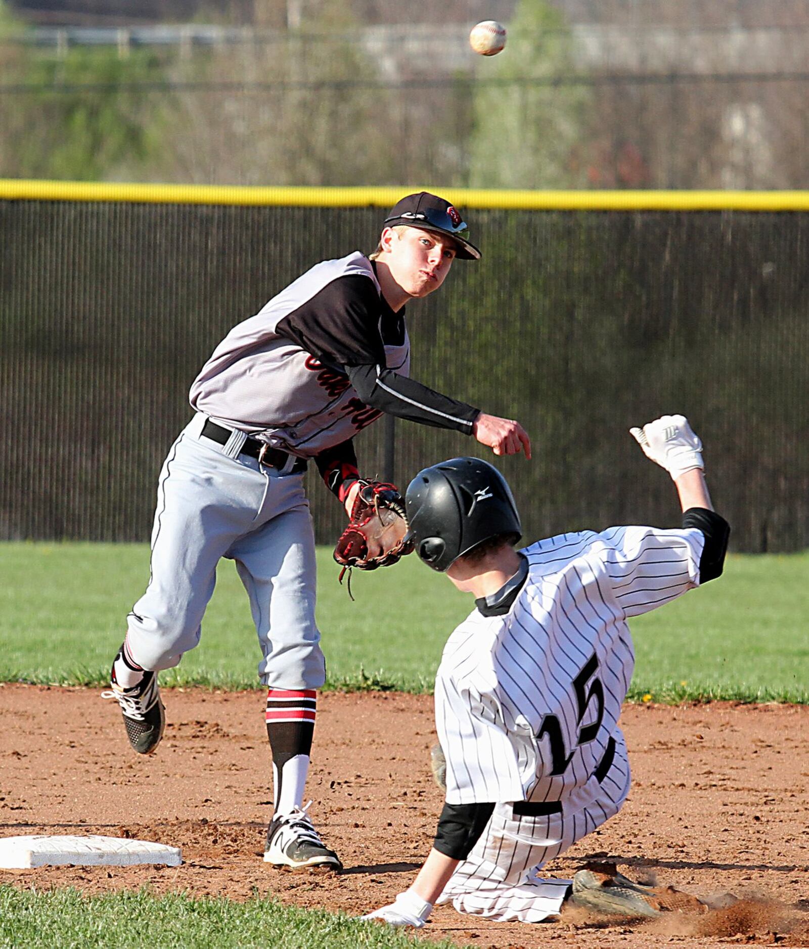 Lakota East’s Mitchell Reardon is out as Oak Hills second baseman Corey Miley turns a double play during Tuesday’s game at East. CONTRIBUTED PHOTO BY E.L. HUBBARD