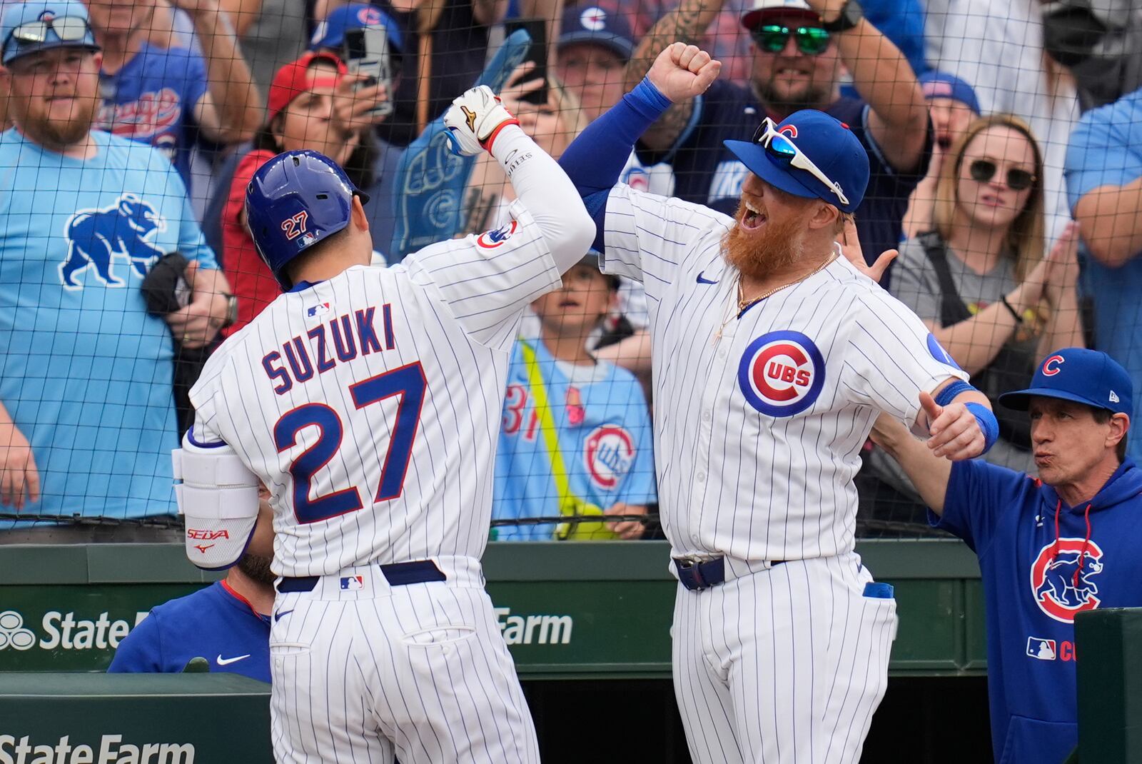 Chicago Cubs' Justin Turner (3), right, high-fives designated hitter Seiya Suzuki (27) after Suzuki hit a home run during the eighth inning of a baseball game against the Arizona Diamondbacks, Friday, April 18, 2025, in Chicago. (AP Photo/Erin Hooley)