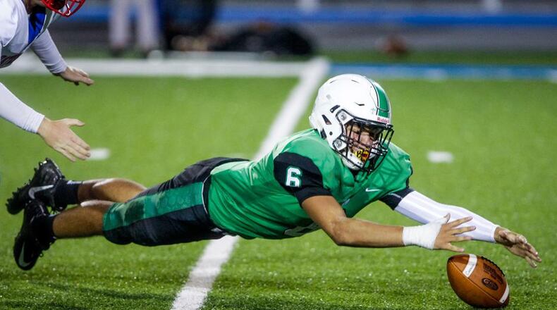 Badin’s Jayden Carter dives to recover a fumble after he knocked the ball away from Carroll quarterback Trent Fox during last Friday’s game at Virgil Schwarm Stadium in Hamilton. The Rams won 24-21. NICK GRAHAM/STAFF