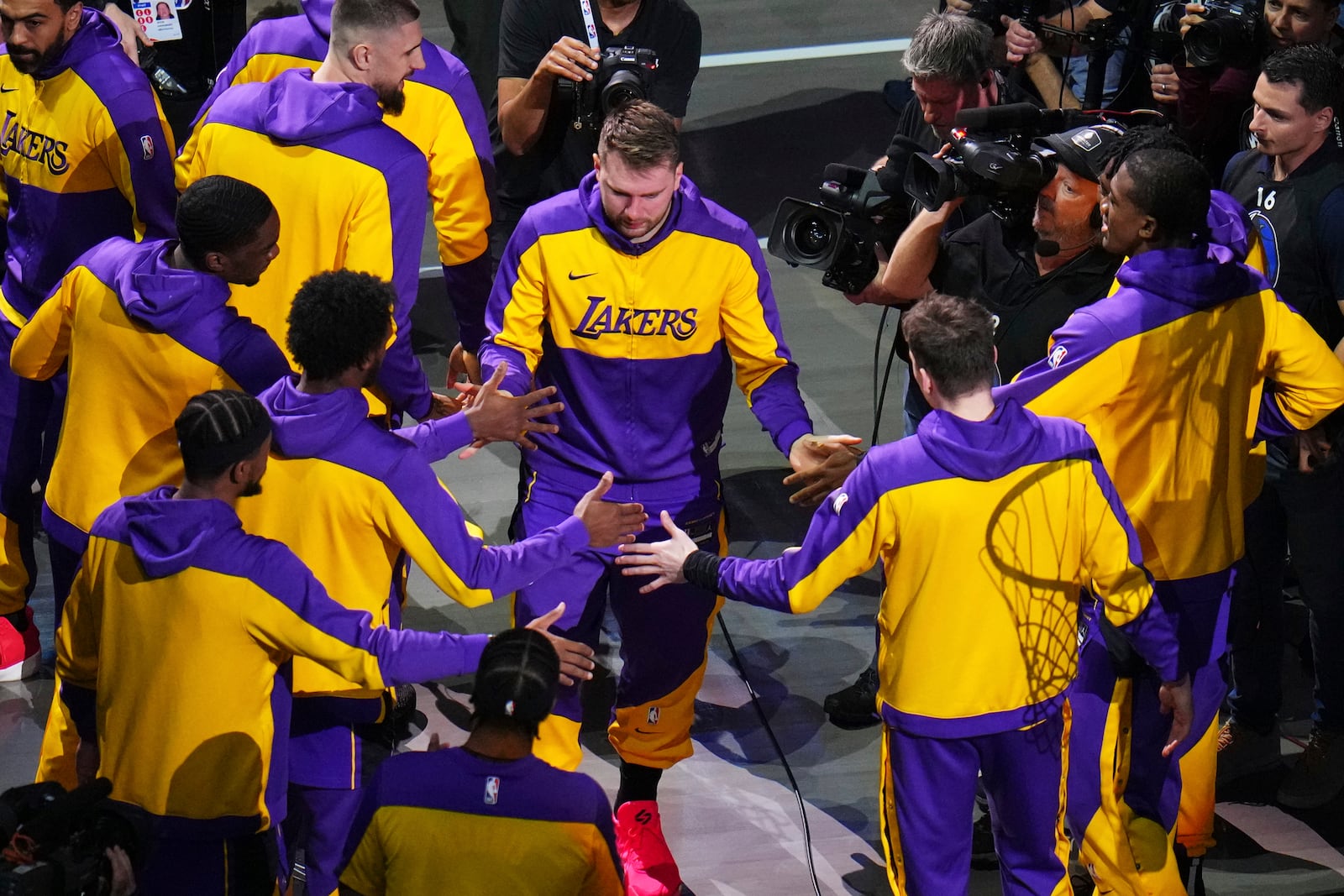 Los Angeles Lakers' Luka Doncic greets teammate during introductions before an NBA basketball game against the Dallas Mavericks in Dallas, Wednesday, April 9, 2025. (AP Photo/Julio Cortez)