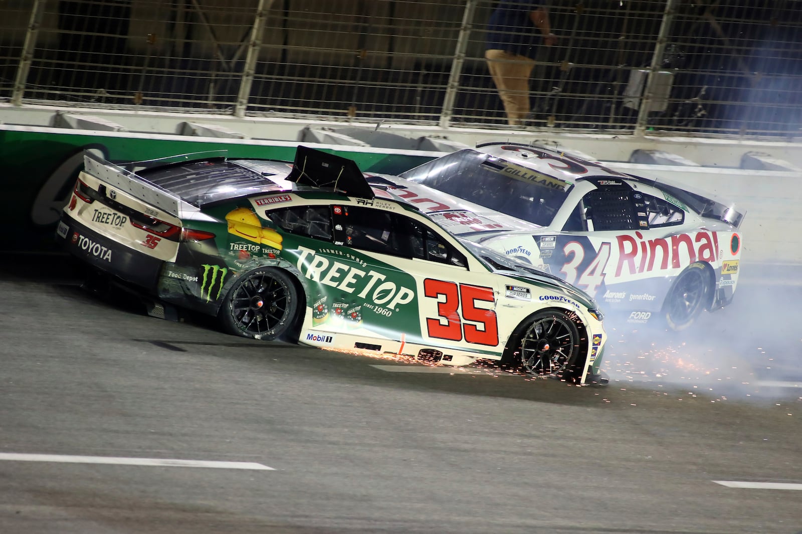 Driver Riley Herbst (35) and Todd Gilliland (34) collide in turn four during a NASCAR Cup Series auto race, Saturday, June 28, 2025, in Hampton, Ga. (AP Photo/Greg McWilliams)