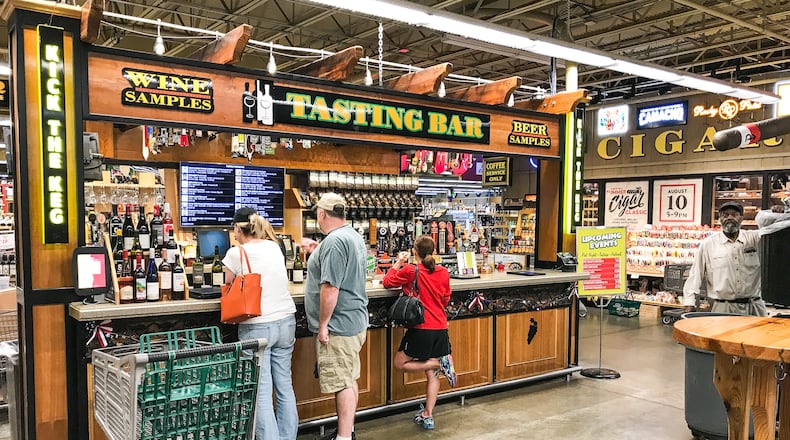 Customers stand at the beer and wine tasting bar at Jungle Jim’s International Market Friday, July 6, 2018, in Fairfield. NICK GRAHAM/STAFF