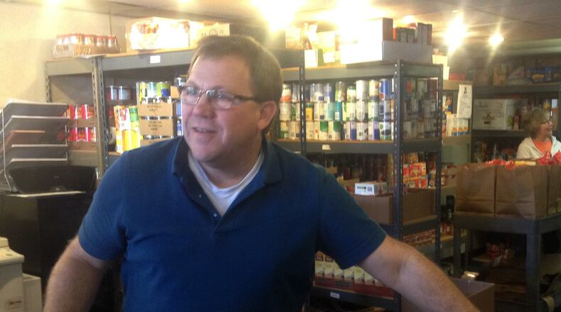 Fairfield Food Pantry co-manager Wayne Patten grabs a container of milk for a food pantry client. MICHAEL D. PITMAN/2016