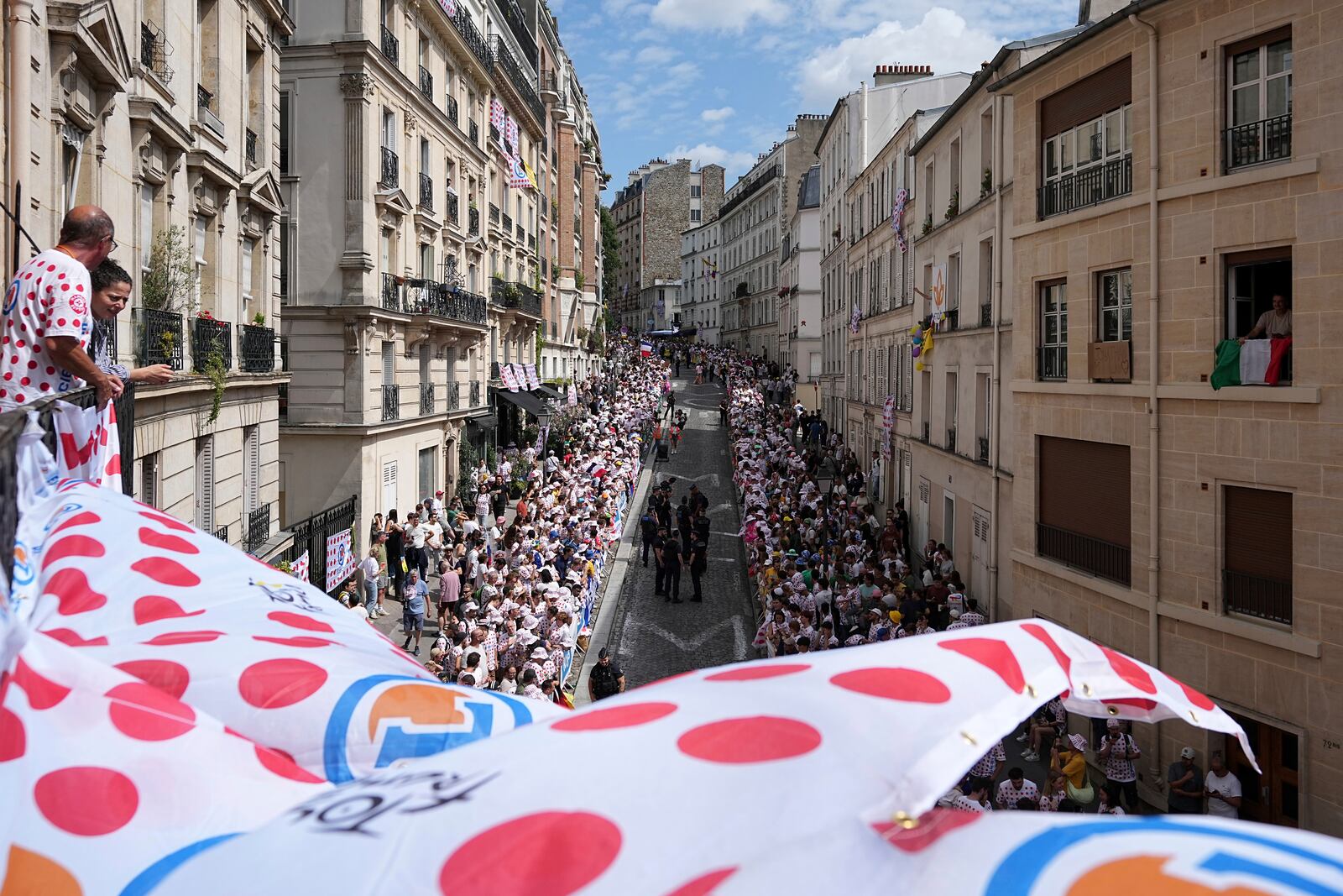 Fan wait for the riders in the street of the Montmartre district before the last stage of the Tour de France cycling race between Mantes-la-Ville and Paris, Sunday, July 27, 2025 in Paris (AP Photo/Laurent Cipriani)