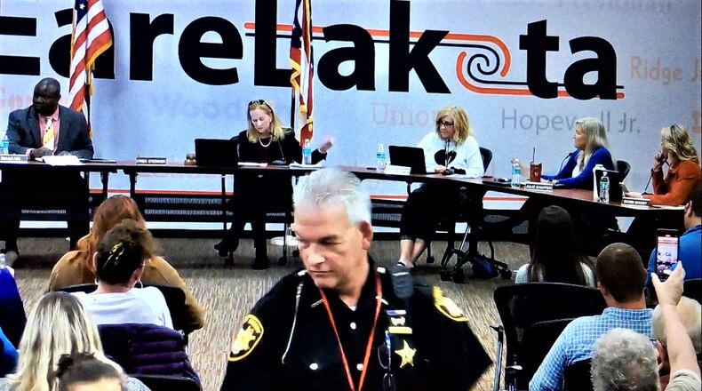A Butler County Sheriff deputy moves among the sometimes raucous crowd at Monday evening's Lakota school board meeting, which saw members vote to temporarily halt comments from the public. The meeting was abruptly adjourned after regular board business had been conducted but prior to the meeting's closing comments by members. (Photo By Michael D. Clark\Journal-News)
