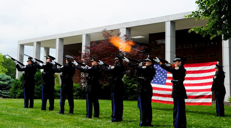 The Middletown Division of Police Honor Guard fires a 21-gun salute during the 2012 police memorial ceremony at Woodside Cemetery. NICK GRAHAM/STAFF