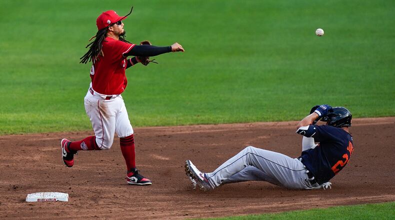 Cincinnati Reds shortstop Freddy Galvis (3) throws to first for the double play the second inning of the exhibition game against the Detroit Tigers at Great American Ballpark in Cincinnati, Wednesday, July 22, 2020. (AP Photo/Bryan Woolston)