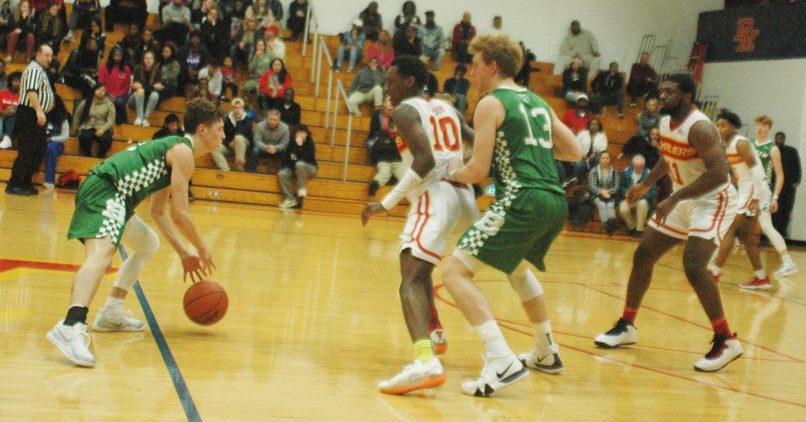 Badin’s Justin Pappas (13) sets a pick on Purcell Marian’s Alex Dotson (10) as Joseph Walsh of BHS dribbles the ball during Friday night’s game at the Eveslage Athletic Center. Host Purcell won 74-60. RICK CASSANO/STAFF