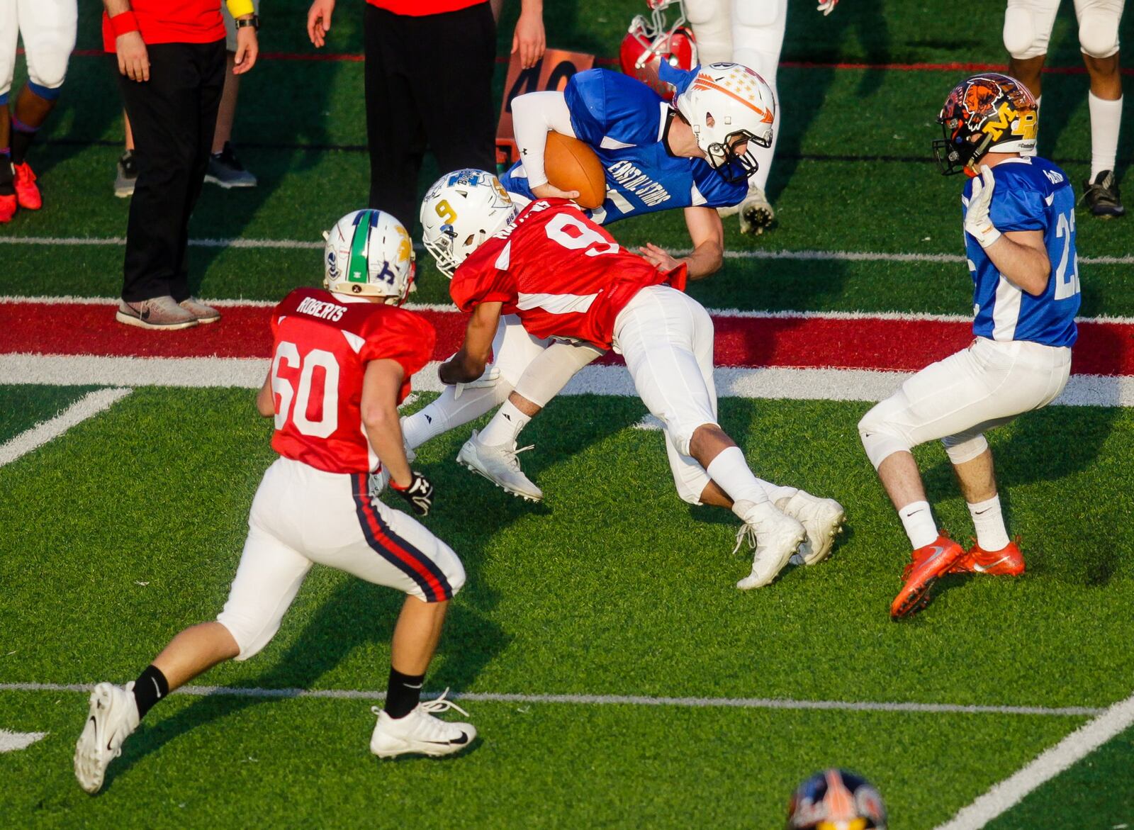 The West’s Gabe Mathews (9) of Hamilton tackles East quarterback Blake King of Milford as Tim Roberts (60) of Talawanda gives chase during the 43rd Southwestern Ohio Football Coaches Association Ron Woyan East-West All-Star Game on Thursday night at Kings. NICK GRAHAM/STAFF