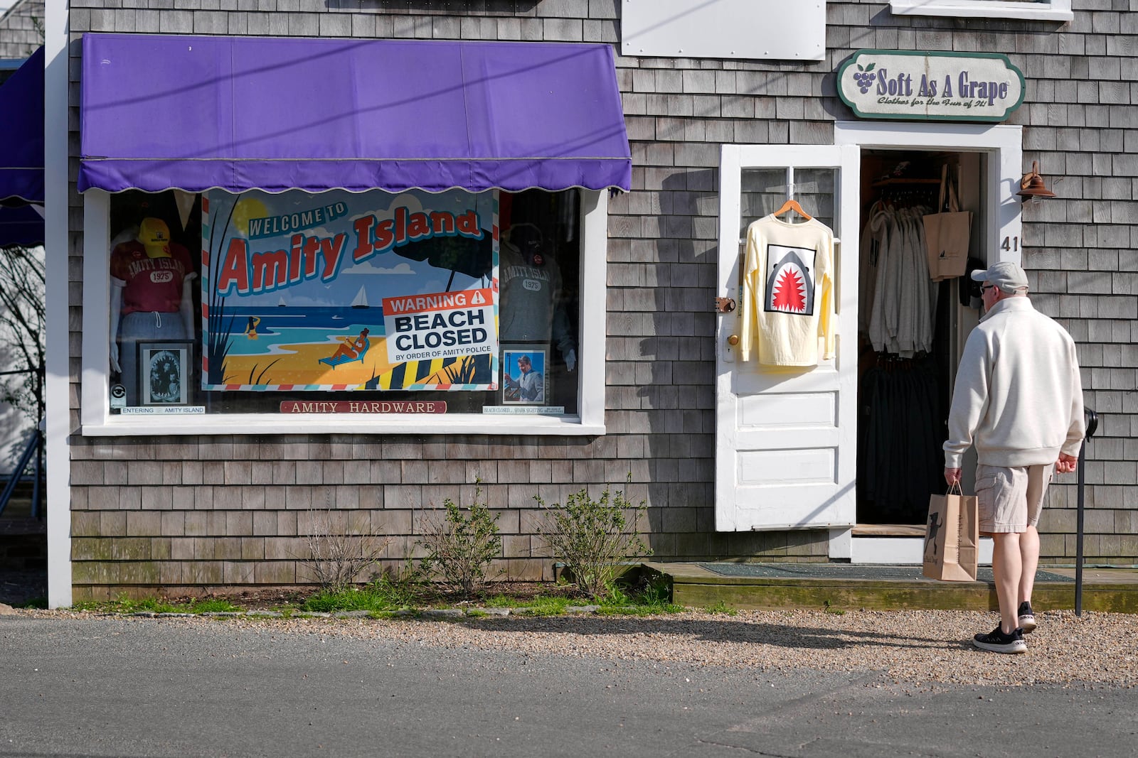 A visitor arrives at a shop selling Jaws-related souvenirs, Wednesday, May 14, 2025, in Edgartown, Mass. (AP Photo/Robert F. Bukaty)