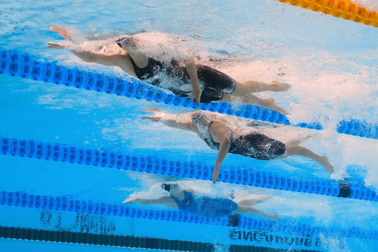 Summer McIntosh of Canada, top, Jamie Perkins of Australia and Maya Werner of Germany compete in the women's 400-meter freestyle final at the World Aquatics Championships in Singapore, Sunday, July 27, 2025. (AP Photo/Lee Jin-man)